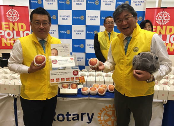 Rotarianos do Distrito 2530 vendendo as maçãs durante a Conferência Distrital.