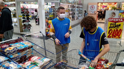 Voluntário Christian e Interactiano Kaique  organizam alimentos arrecadados.
