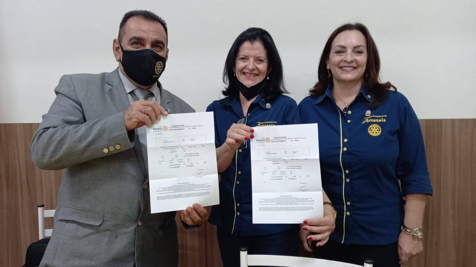 Governador 2021-22 Luis Carlos recebendo comprovantes de doação à Fundação Rotária , da tesoreira Isabel Bernardi e presidente Darlene Lisboa