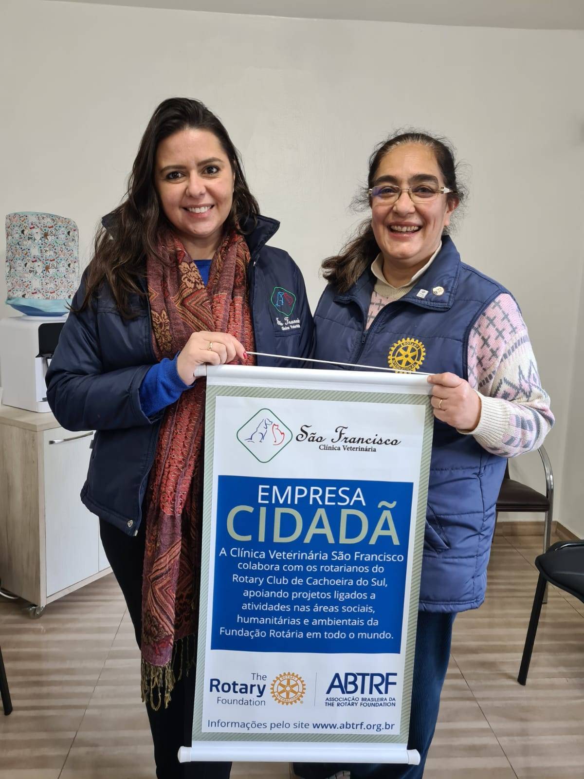 Aline Vargas e Fatima Beatriz de Castro Santos com o banner do Programa Empresa Cidadã