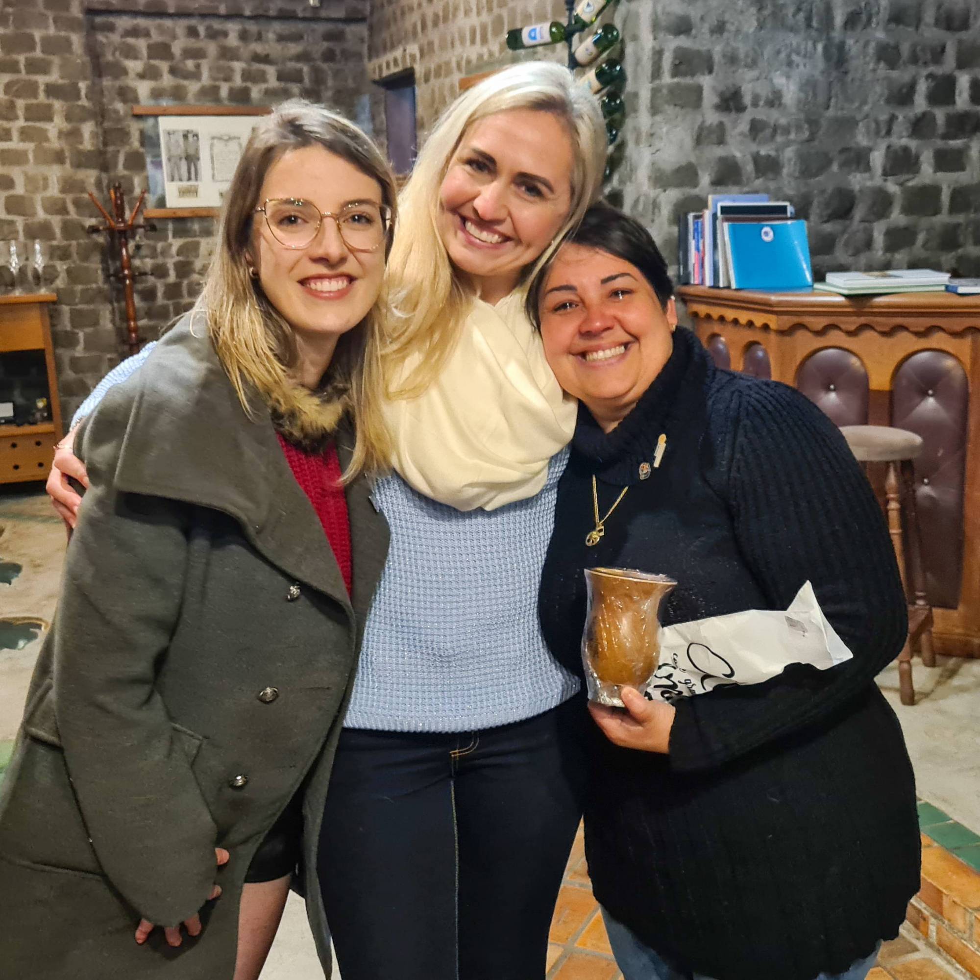 As companheiras Luma e Loydi presenteiam Scheila com uma cuia do clube.