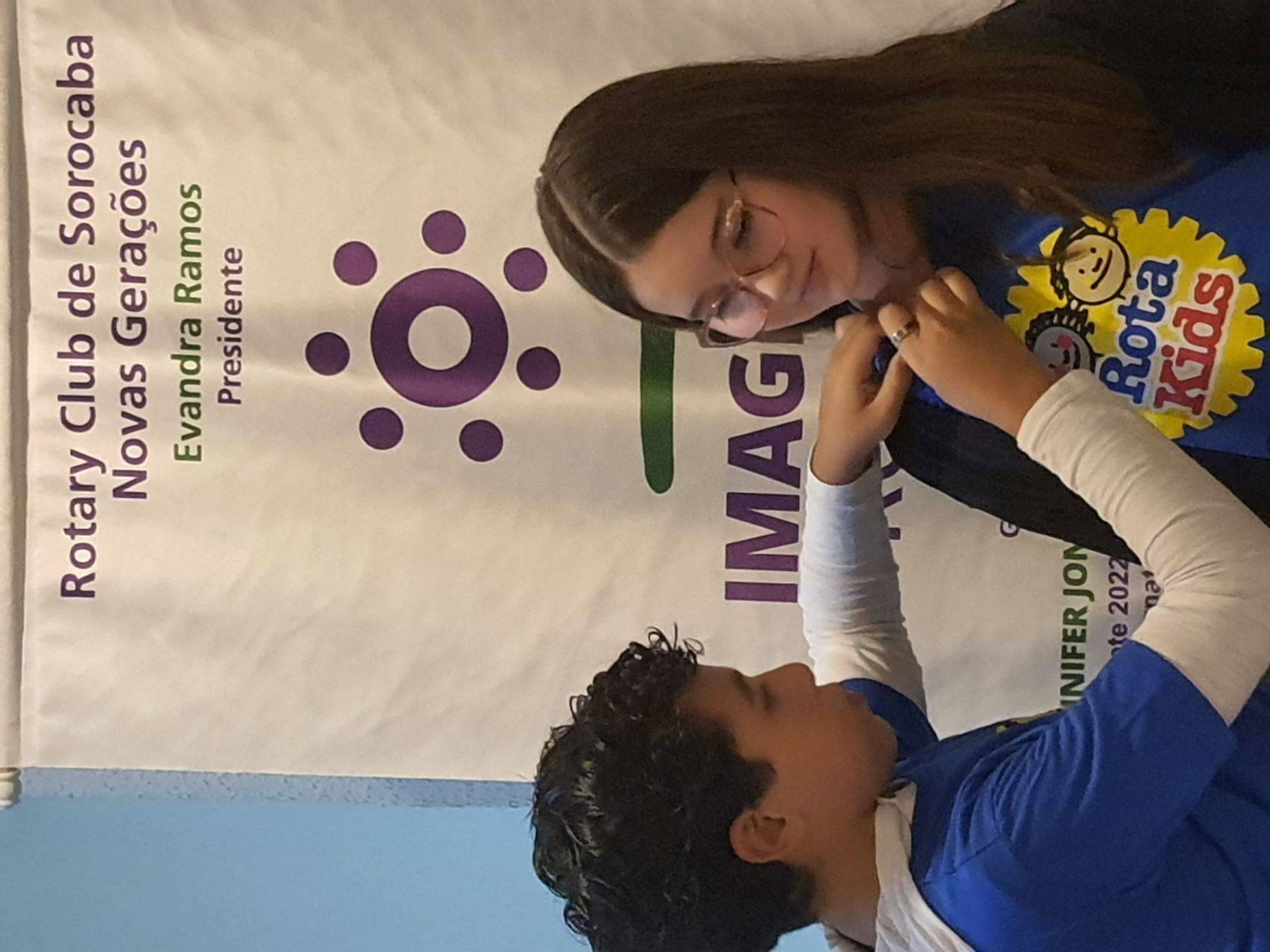 Felipe Santana Ricci, presidente 2021/2022  colocando o pin na presidente 22/23, Isadora Mikelides, 