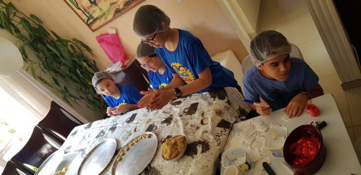 Usando touca e avental os pequenos criaram delicias na cozinha