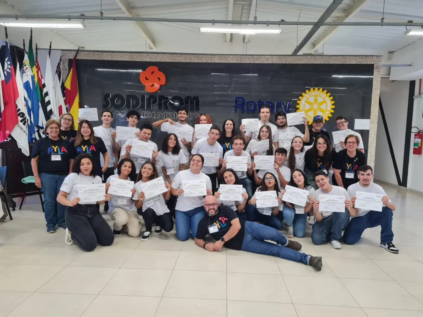 Jovens participantes exibem certificado de participação no RYLA