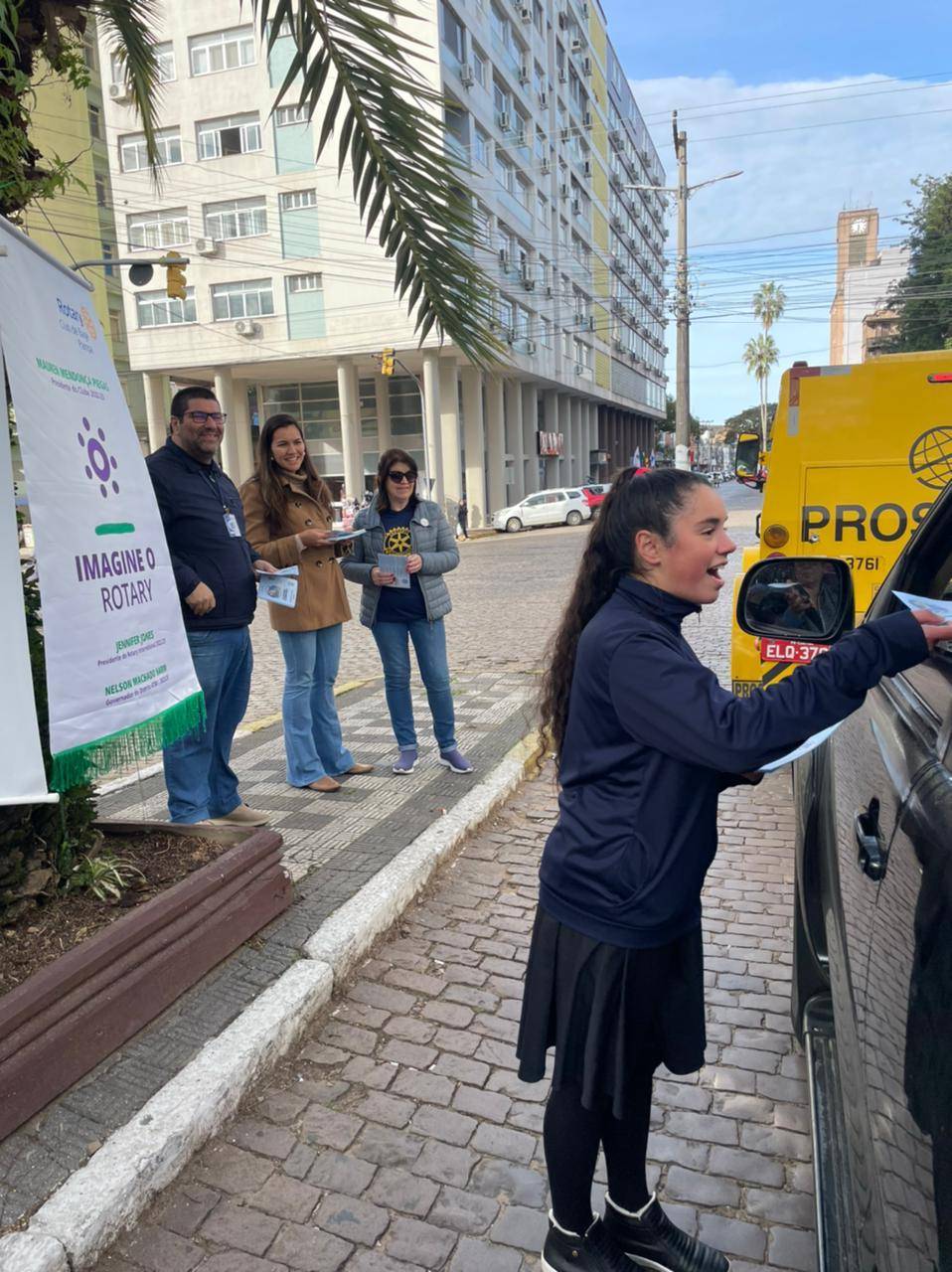 Vencedora do prêmio RYLA distribuindo flayer sobre Meio Ambiente - A Água desenvolvido por ela. RC de Bagé Pampa, Daeb e Escola Municipal Cívico Militar João Severiano da Fonseca