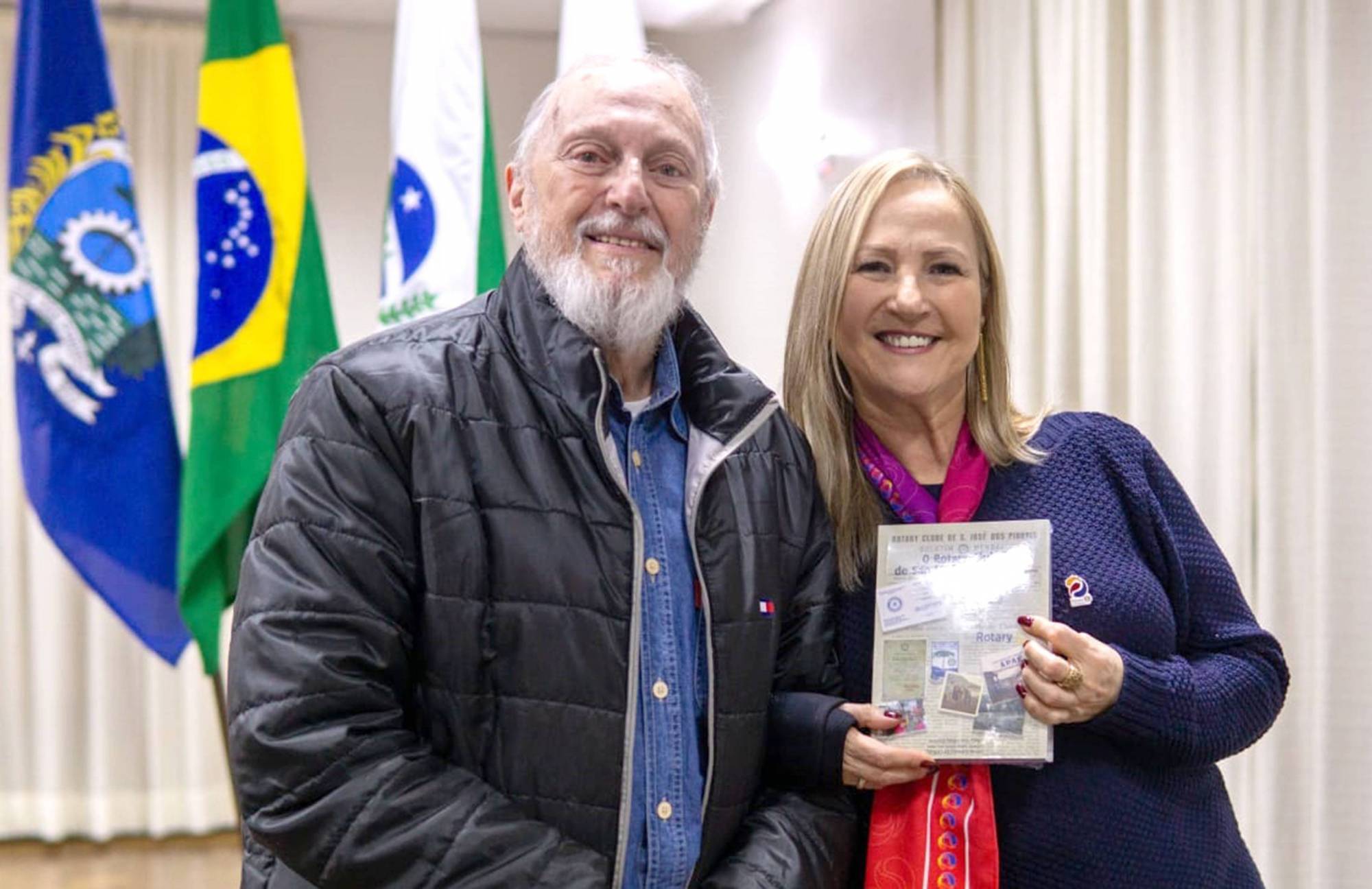 O governador do Rotary Club Distrito 4730 (ano 1989/1990), Lourival Loir Berti entregando o livro da história do Rotary Club São José dos Pinhais, do qual faz parte desde 1972, para a ilustre visitante, a governadora assistente Regina Damazio