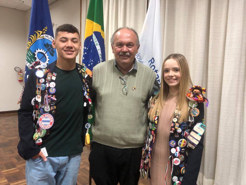 O presidente do Rotary Cllub São José dos Pinhais, Miguel de Paula, ladeado pelos intercambistas Paulo Augusto Maruska e Kiara Mulik Vilarinho