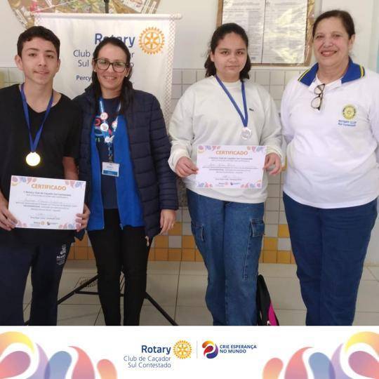 Diretora da Fundação Rotária Regina Linhares Martelo com a Professora que conduziu a atividade é a Michele Moraes Alvarenga e os ganhadores do concurso.