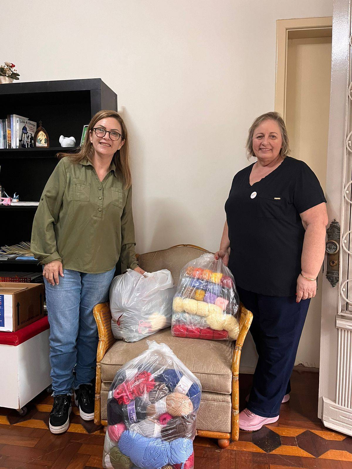 Na foto a companheira Dulce Caleffi entrega os novelos arrecadados para a companheira Andrea Dumoncel.