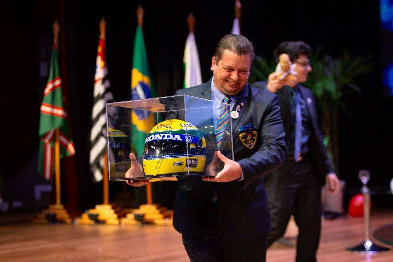 Governador 2024-25, Alfredo Arten Junior, conduzindo uma réplica do capacete de Ayrton Senna, que será entregue como Troféu Presidente Irresistível