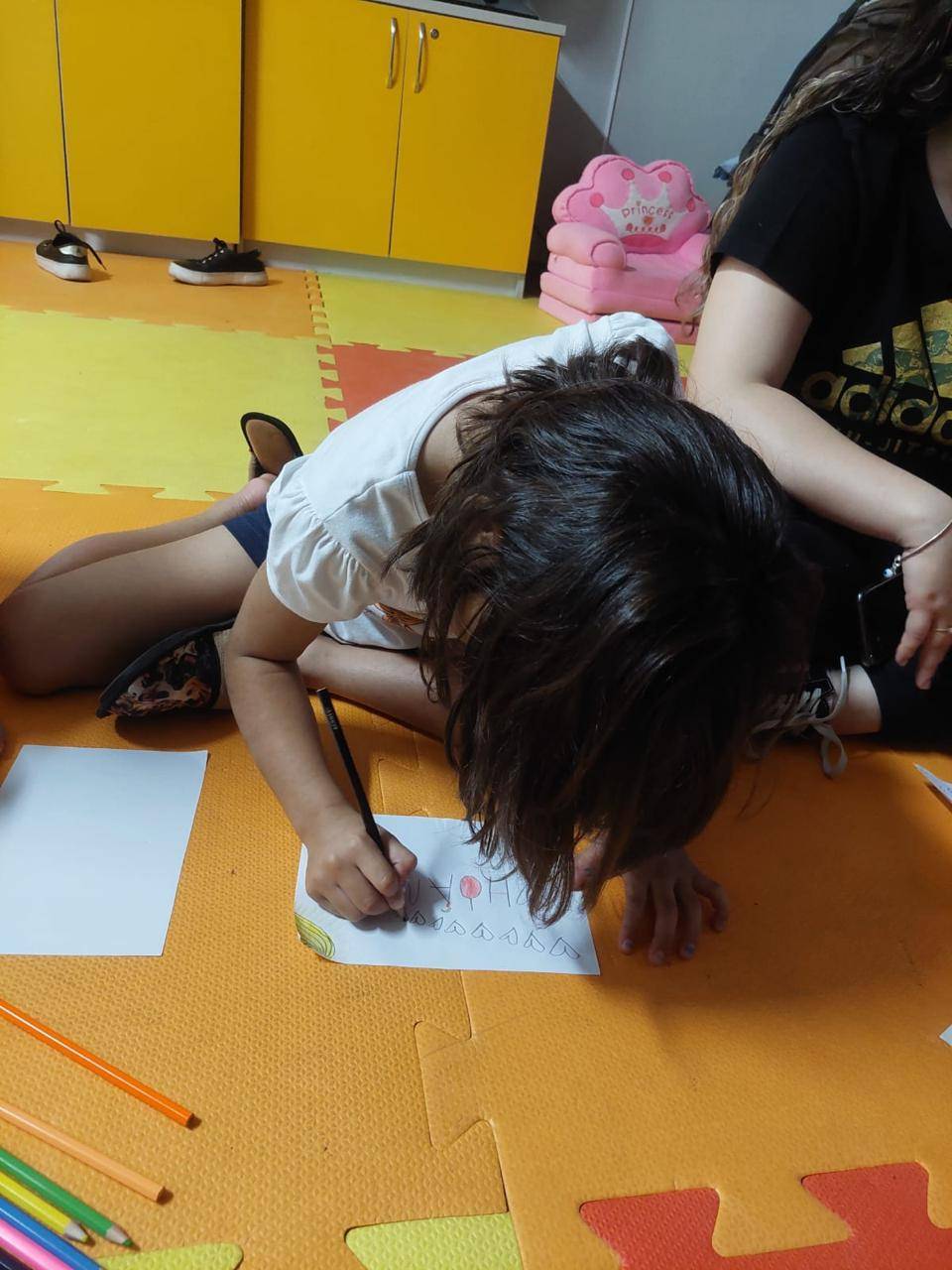 Foto tirada durante o projeto, menina fazendo uma atividade sobre letras.