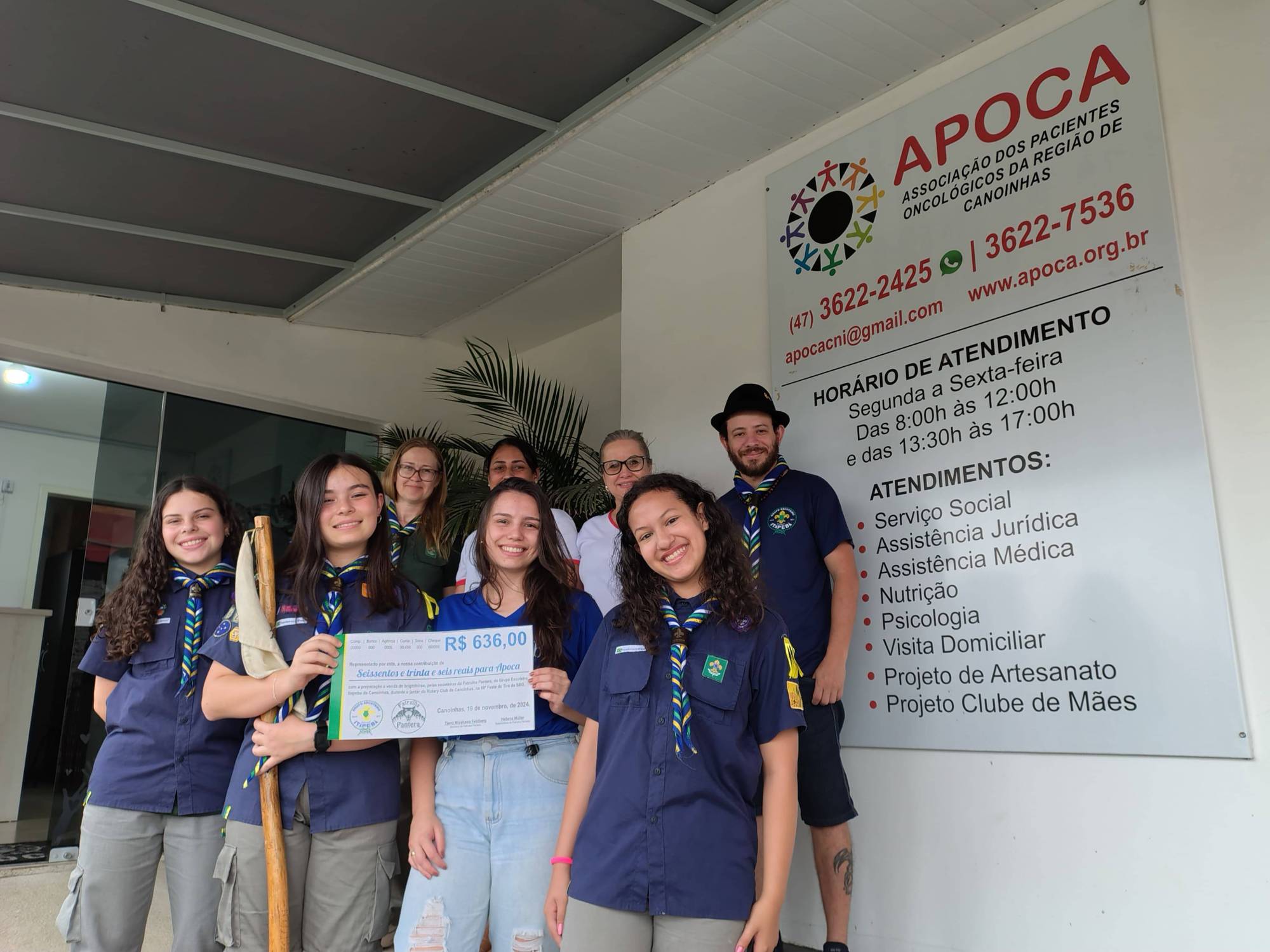 Escoteiras fazem entrega do dinheiro arrecadado com a venda dos brigadeiros para a APOCA