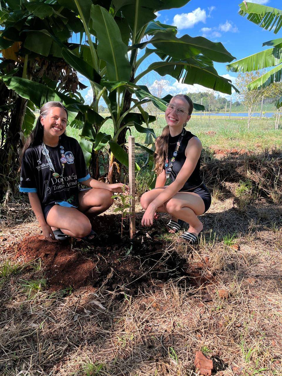 Duas interactianas com um das árvores que foram plantadas.