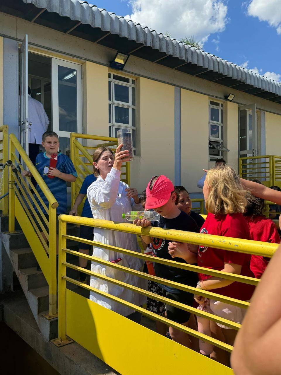 A imagem apresenta uma foto das crianças e trabalhadores da Corsan.