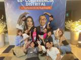 Associados posam em frente ao banner da 68ª Conferência Distrital: ''A Conferência da Superação''.
