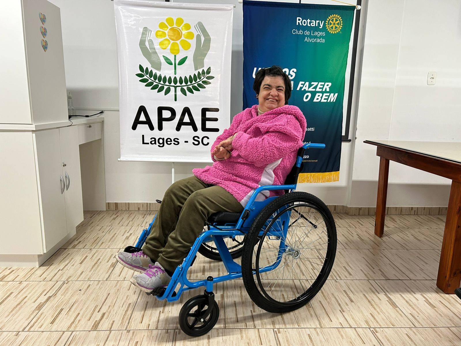 Estudante Olga da APAE Lages, recebendo a sua nova cadeira