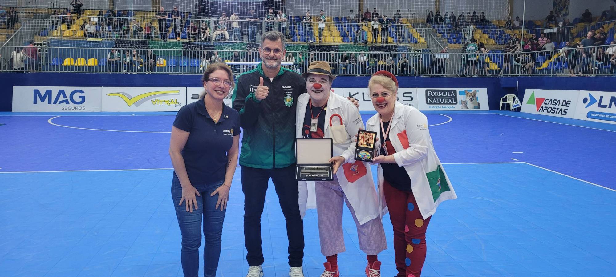 Foto legenda: "Presidente do Marreco Futsal, Luiz Sérgio Lavarda (Lavardinha), ao lado da presidente do Rotary Club de Francisco Beltrão Industrial, Thalita Grando Rauen, e dos coordenadores do Projeto Semeando Sorrisos, José Carlos Kniphoff e Telma Kniphoff." Foto: Gerson Thimothio (Th)