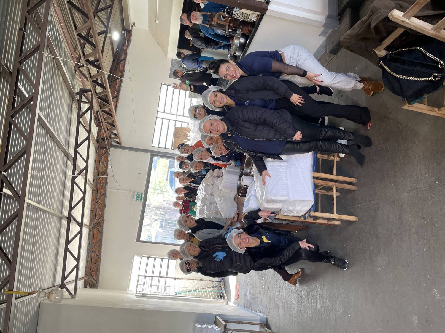 Companheiras e voluntários no preparo das porções 