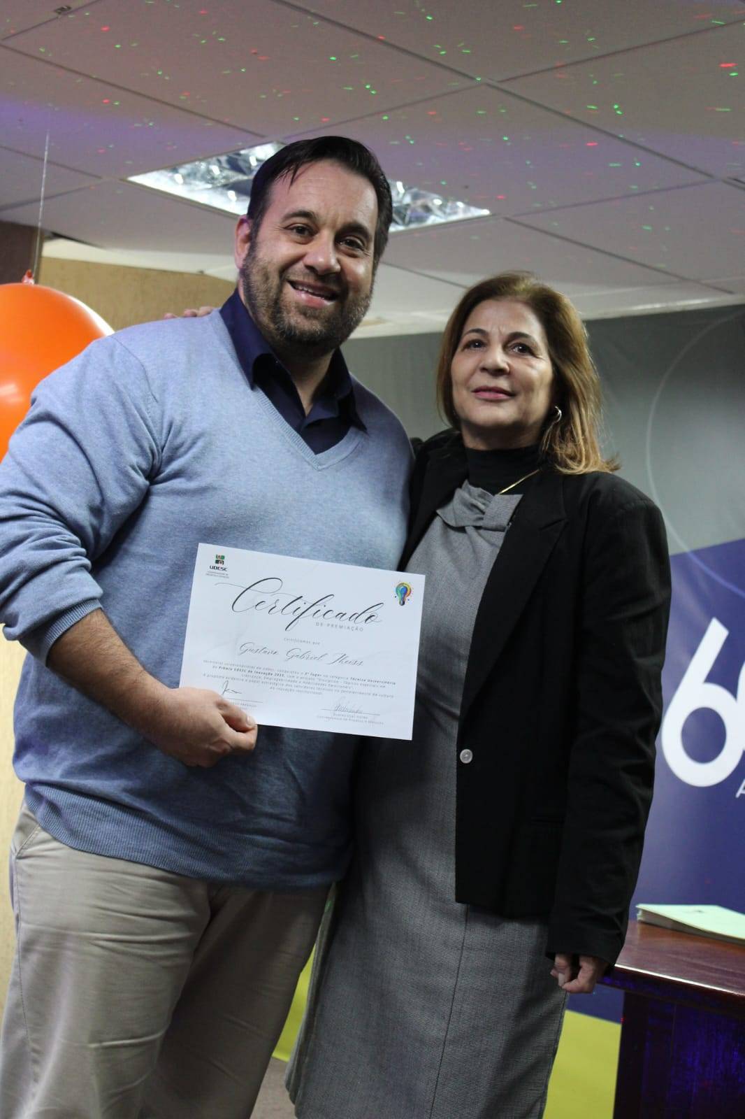 Companheiro Gustavo recebendo a premiação em evento da UDESC