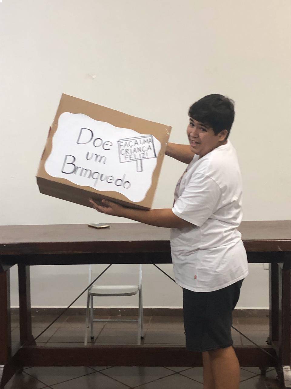 Associado Dudu está segurando uma caixa de papelão onde os brinquedos deverão ser colocados