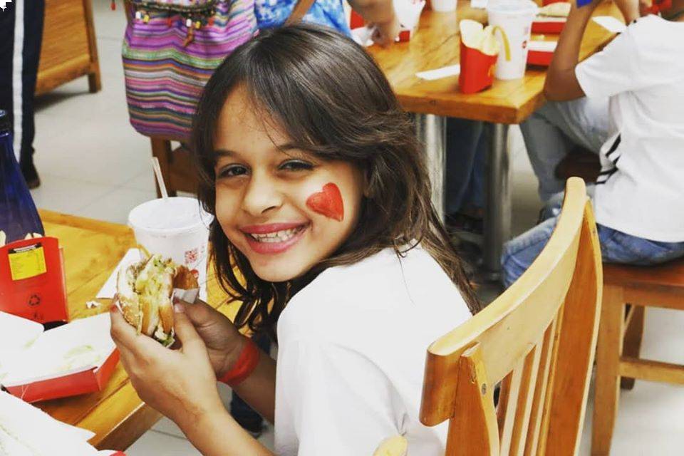 Criança feliz degustando o lanche no dia da ação;