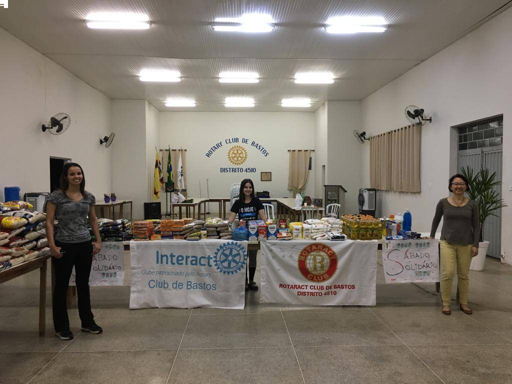 Na imagem, a Presidente do Rotary Club de Bastos, Dirce Kakimoto; Presidente do Rotaract Club de Bastos, Camila Juliana; e Presidente do Interact Club de Bastos, Ana Lara; posicionadas junto a parte dos itens arrecadados, na sede do Rotary Club de Bastos.